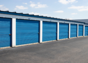 This is an image of a white storage building with blue doors.