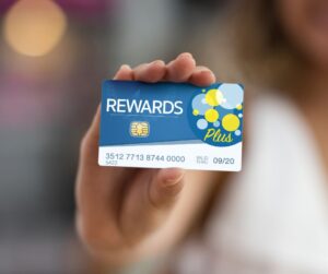 This is an image of a hand holding a rewards program card.