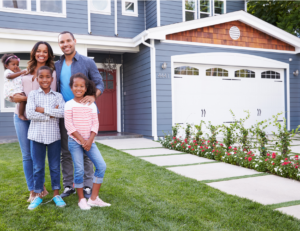 This is an image of a family standing in front of a blue house.